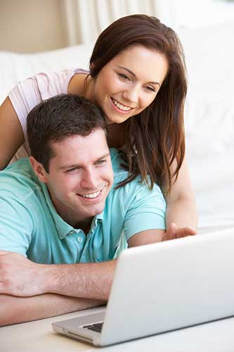 Happy couple looking at laptop