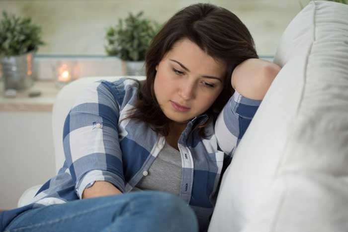 Desperate girl sitting on the sofa